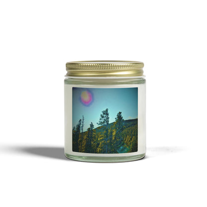 Candle jar with a scenic label featuring trees and a sky.