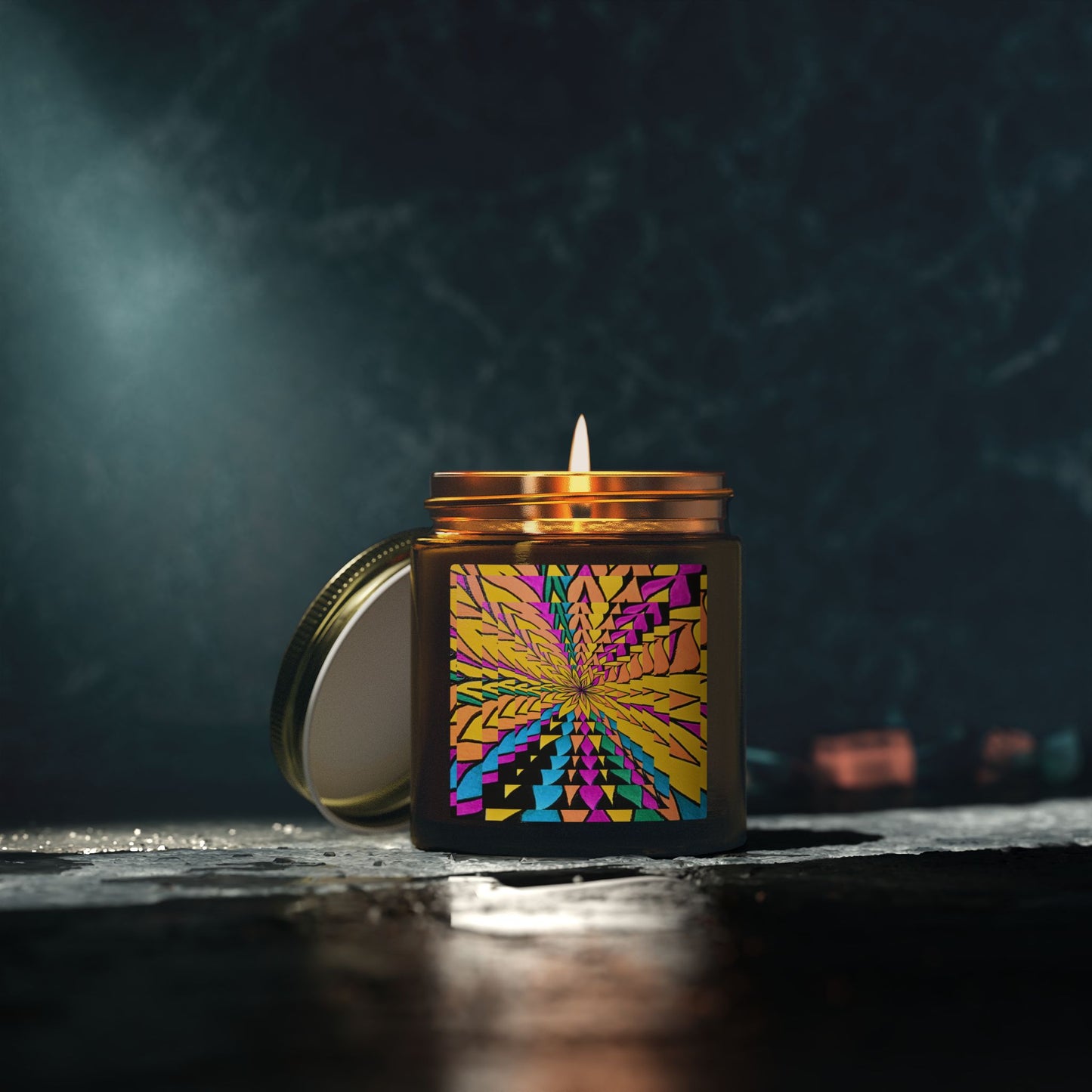 Candle in a decorative container with a colorful design on a dark background