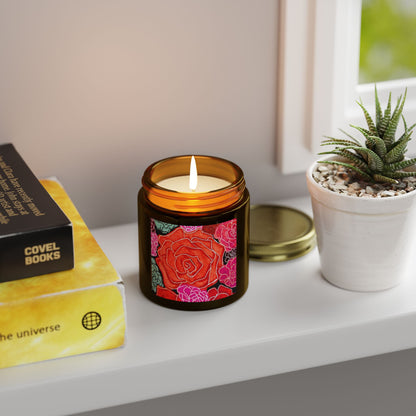 Candle with floral design on a shelf next to books and a plant