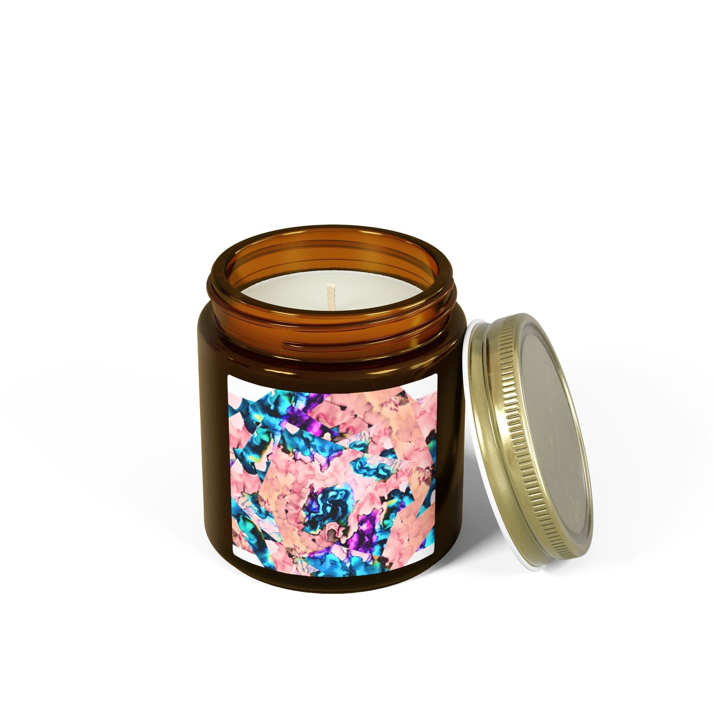 Candle in an amber jar with a colorful label and gold lid on a white background