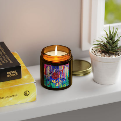 Candle with colorful label on a shelf next to books and a plant