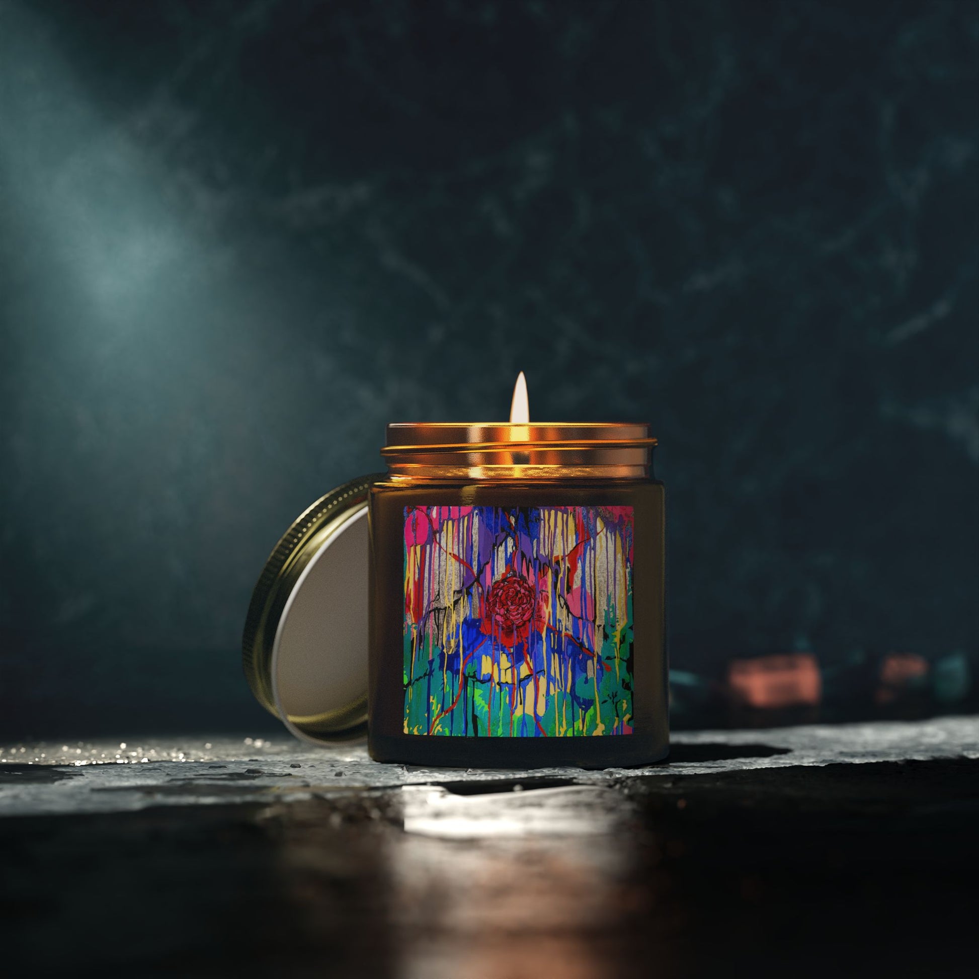 Candle in a decorative jar with a colorful design on a dark background