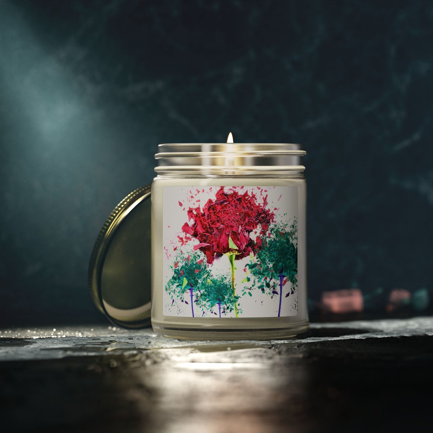 Candle with a colorful floral design on the label against a dark background