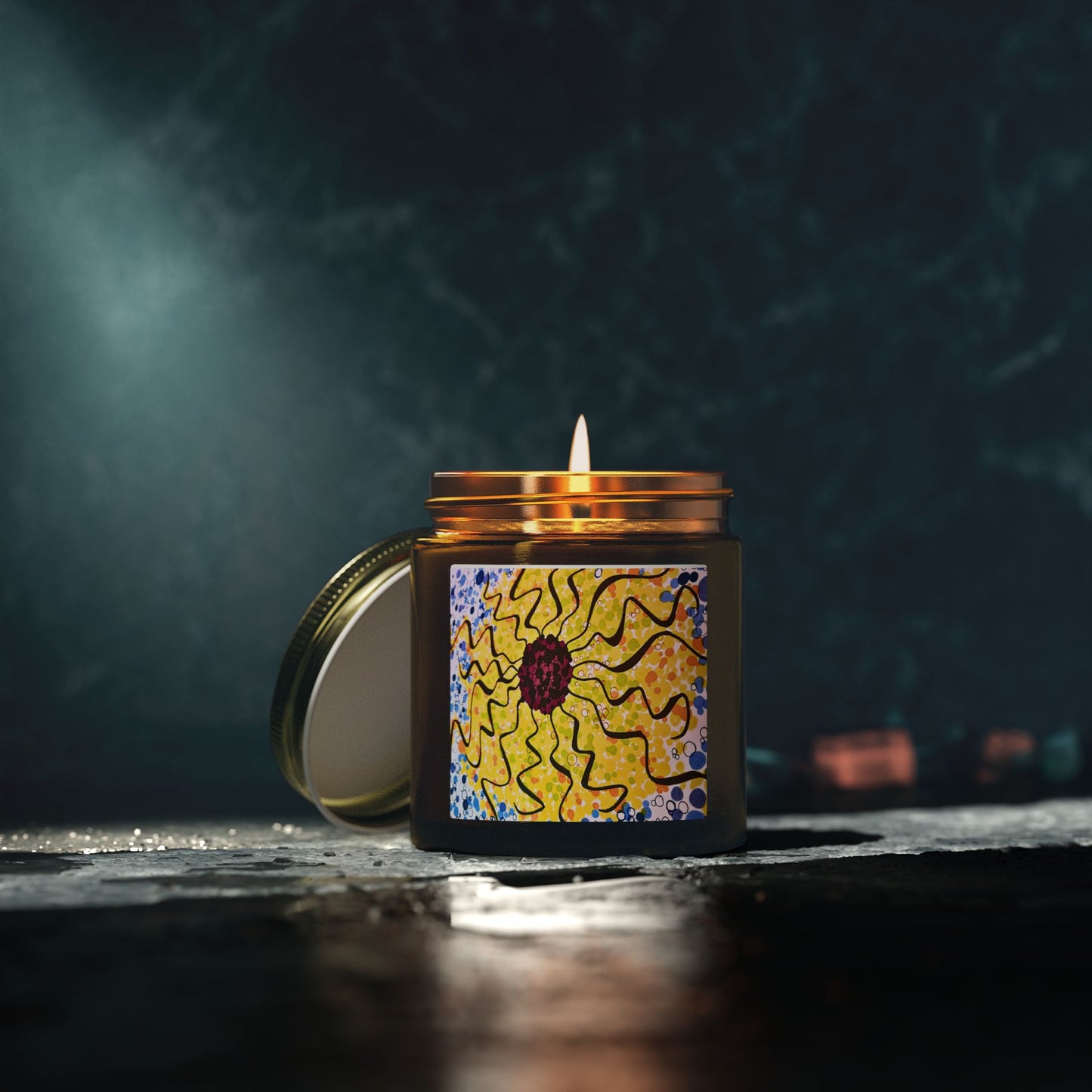 Candle in a decorative jar with a sun design on a dark background