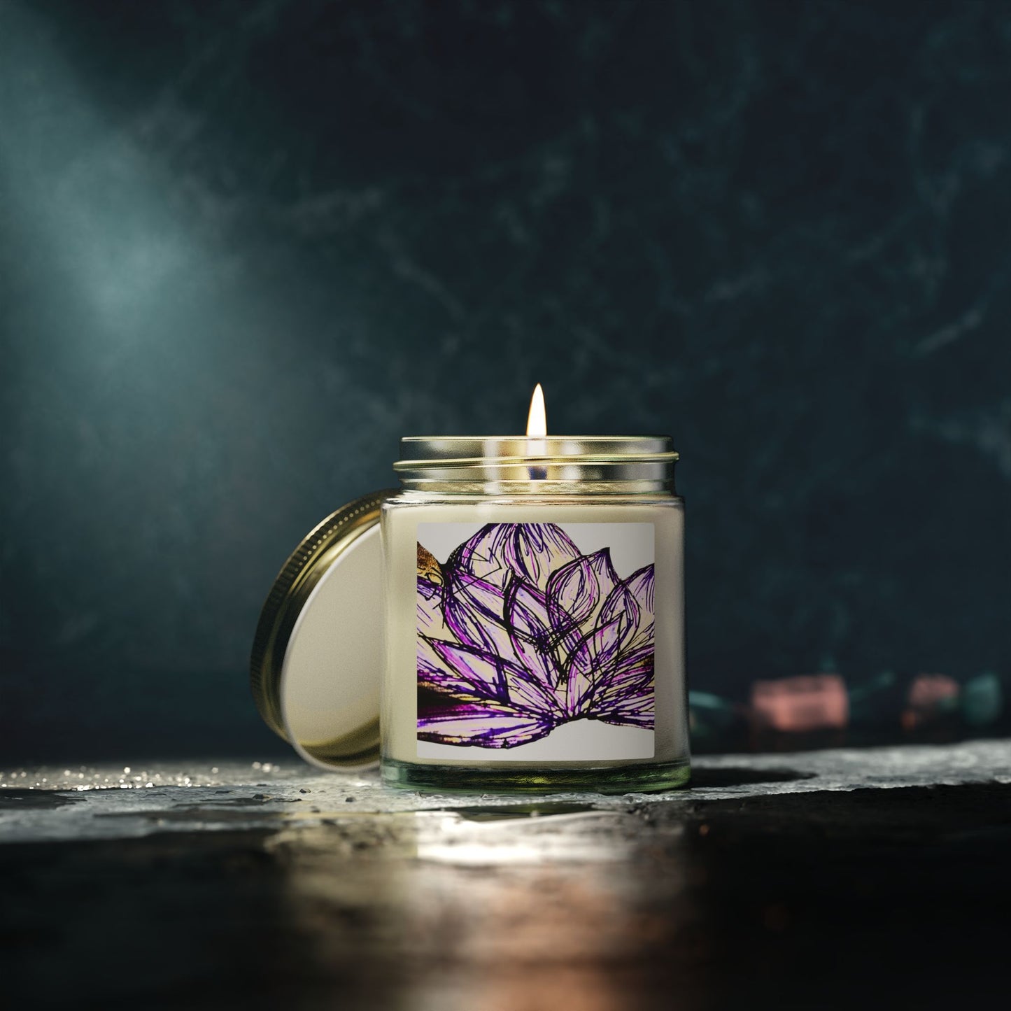 Candle in a glass jar with a purple flower design on a dark background